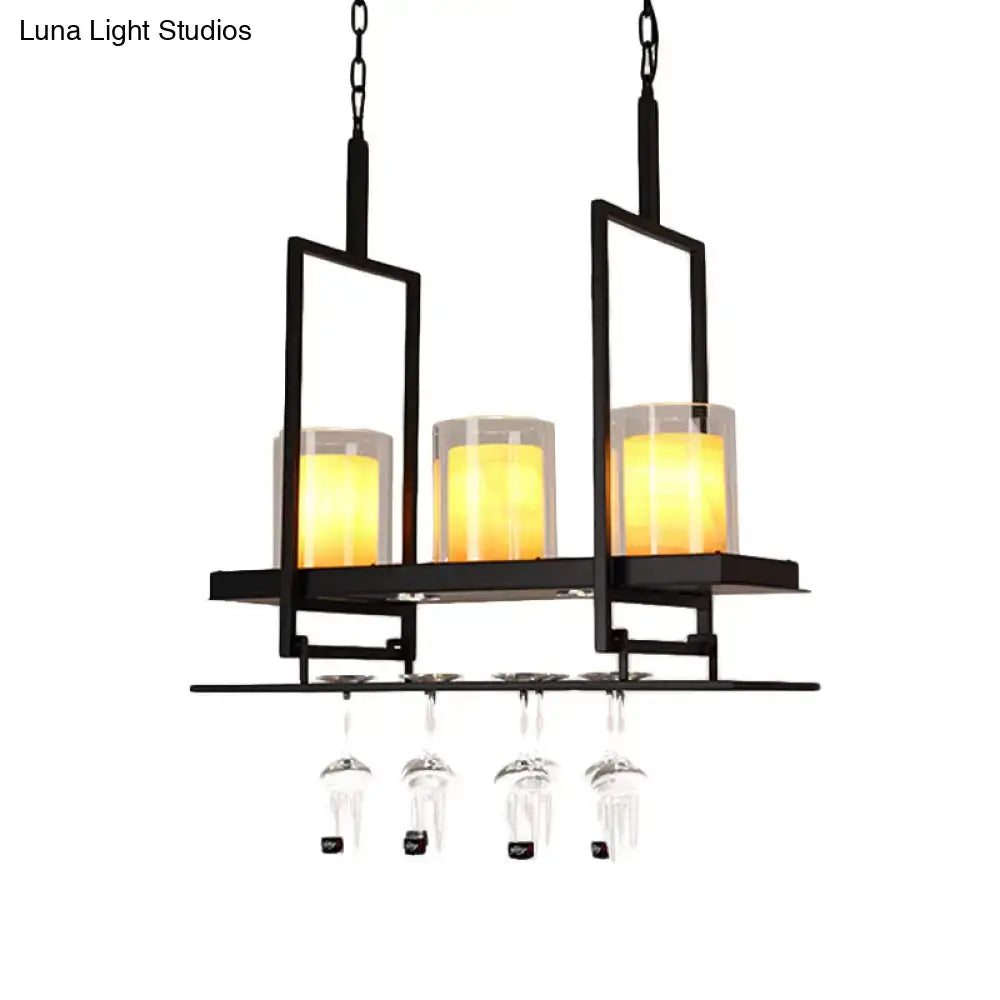 Black metal chandelier with three warm yellow candle-style lights and metal wine glass rack under traditional black marble pendant