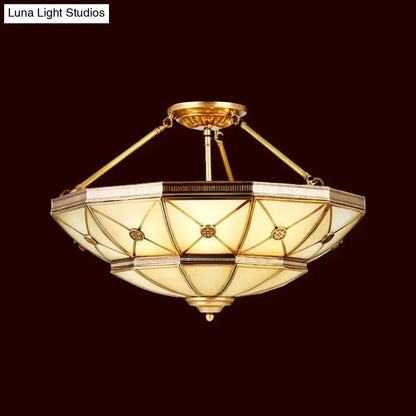 Gold-toned semi-flush mount fixture with geometric stained glass and brass accents 23.5 to 32 inch width 220v-240v