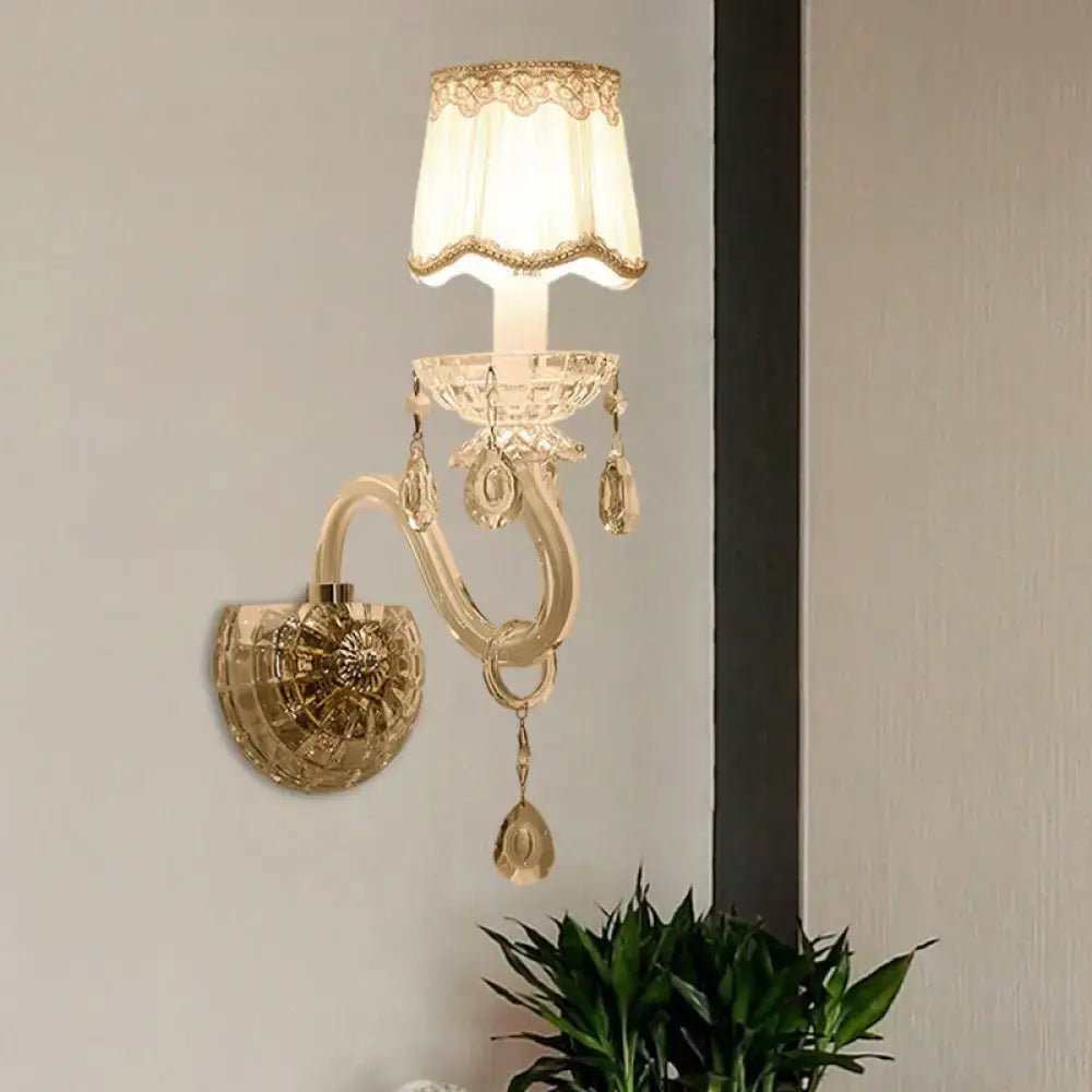 Elegant gold-toned traditional candle wall lamp with crystal accents and a lace-trimmed cream lampshade for bedroom use