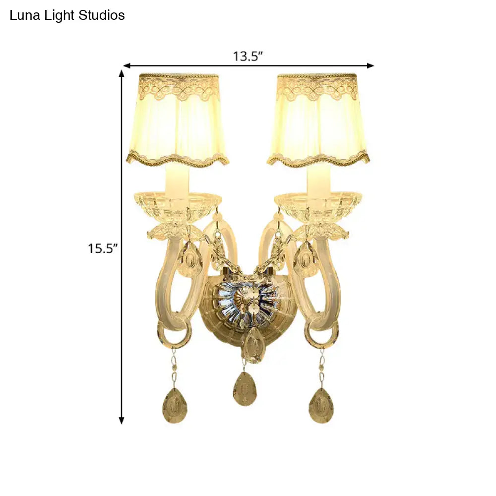 Traditional gold crystal candle wall lamp with ornate design cream lace shade and dangling teardrop pendants for bedroom