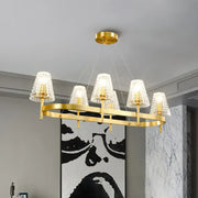 Traditional gold island pendant light with five textured glass shades and a sleek oval frame for dining room use