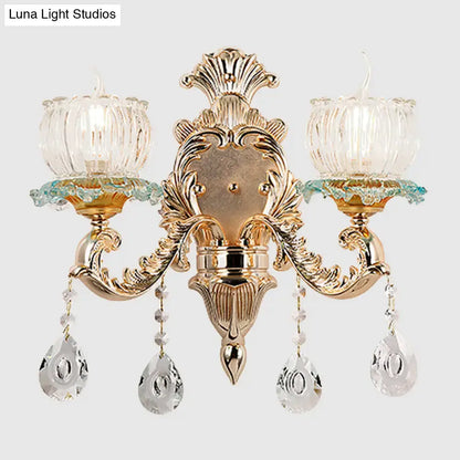 Traditional gold crystal wall sconce with e12 glass candle shades and dangling teardrop pendants for restaurant lighting