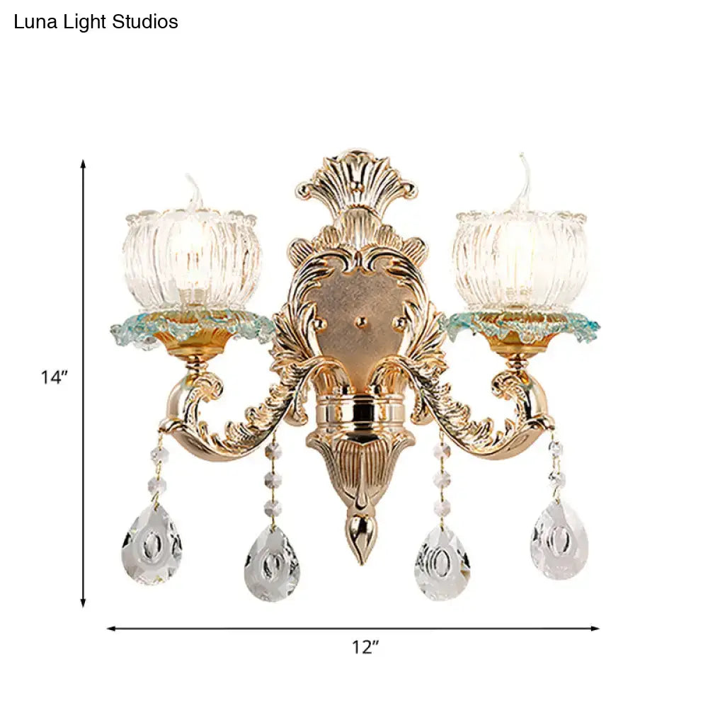 Traditional gold crystal wall sconce with e12 fluted glass candle holders and dangling teardrop pendants for restaurant lighting