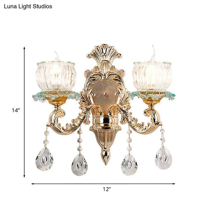 Traditional gold crystal wall sconce with e12 fluted glass candle holders and dangling teardrop pendants for restaurant lighting