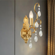 Traditional gold metal candle wall lamp with ornate design and dangling crystal teardrops for living room use