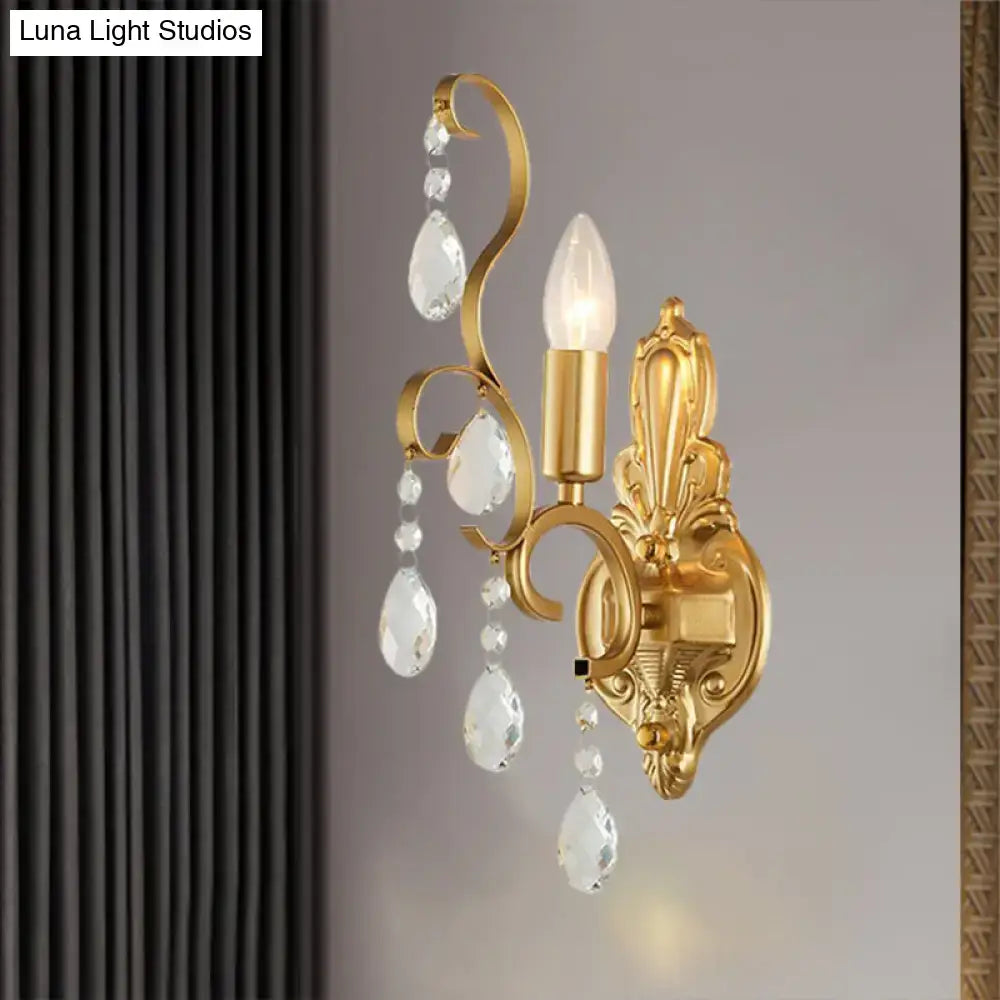 Traditional gold metal candle wall lamp with ornate design and crystal teardrop pendants as a living room wall lamp