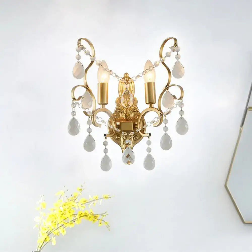Traditional gold metal candle wall lamp with three candle-style bulbs and dangling white teardrop crystals wall sconce