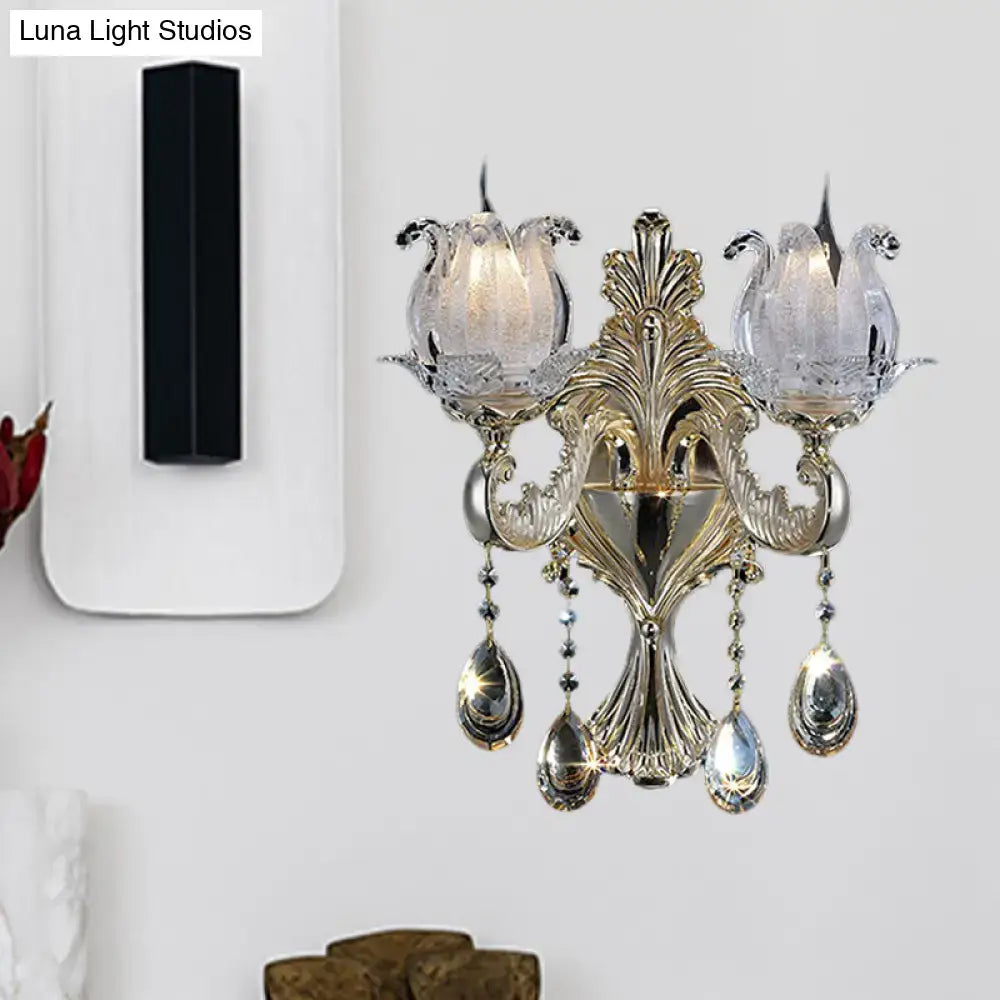 Gold-toned traditional living room wall sconce with frosted glass tulip shades and dangling teardrop crystals