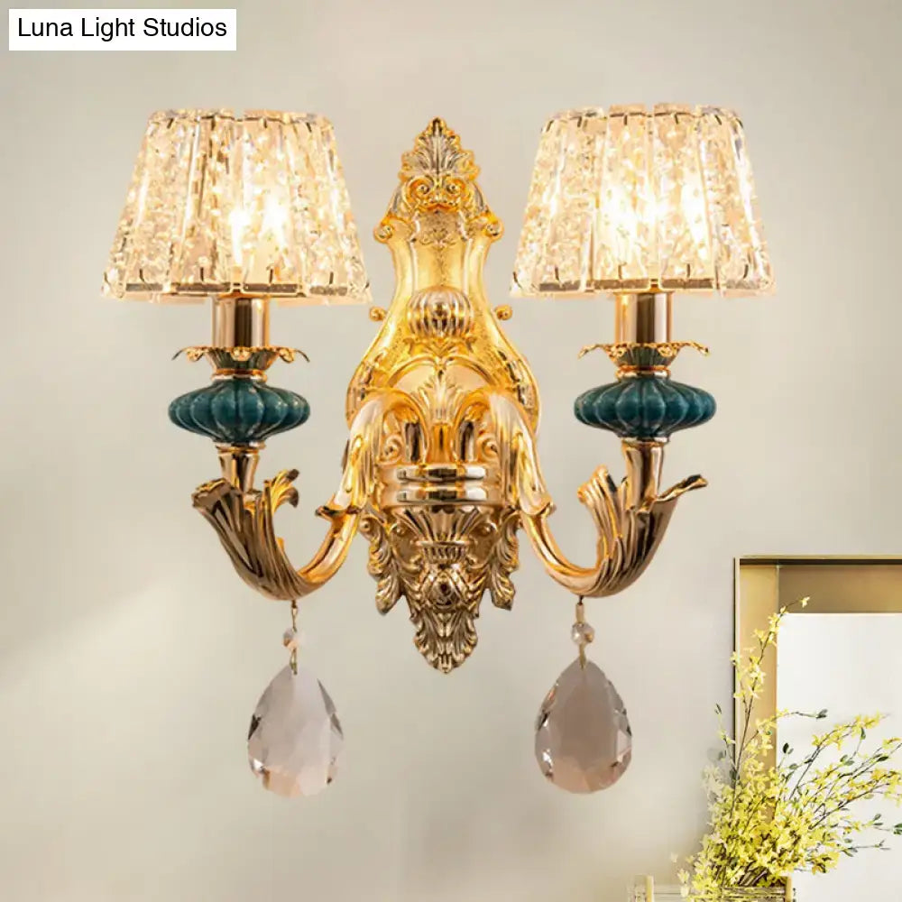 Gold-toned traditional seedy crystal drum wall mount bedroom sconce with teal glass accents and crystal lampshades