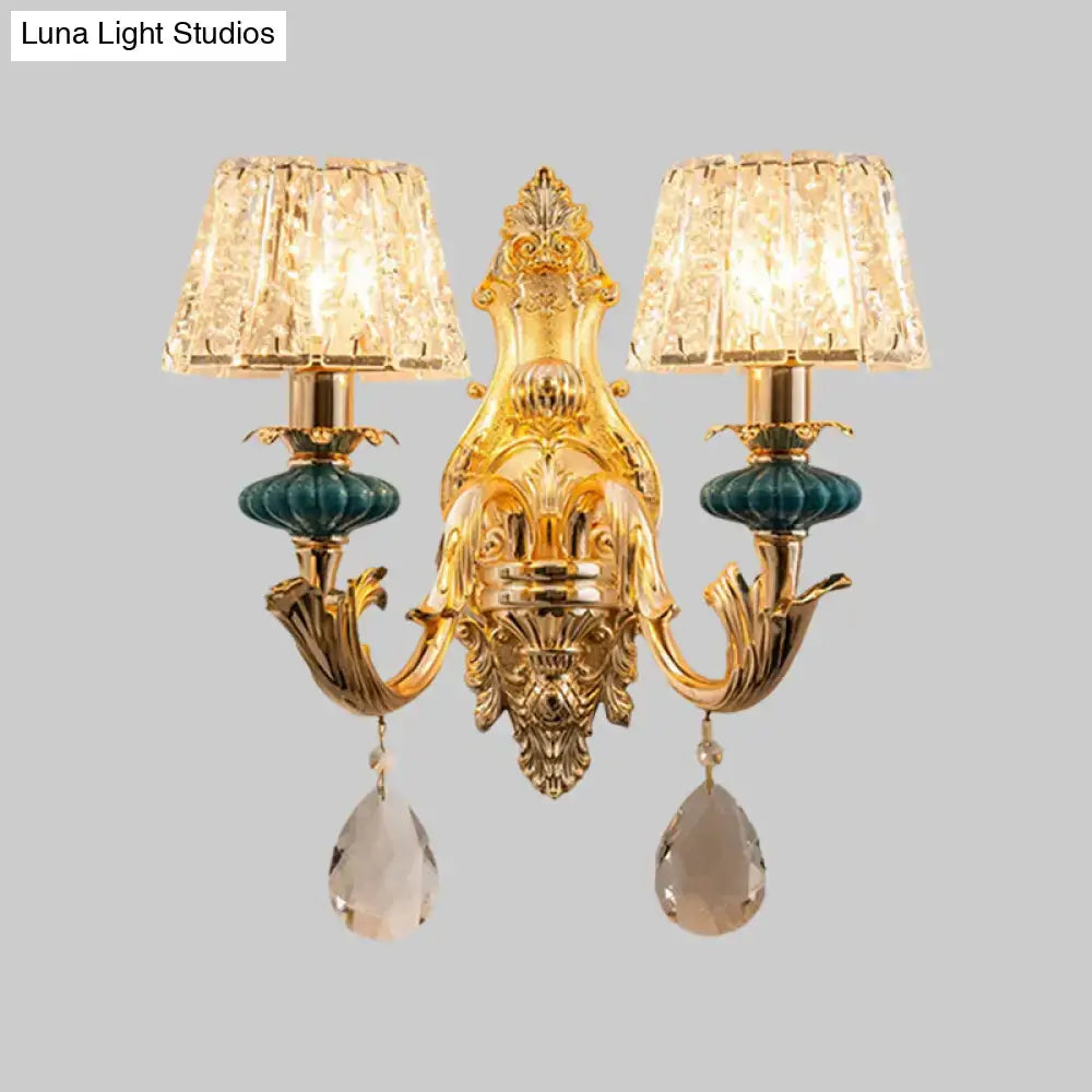 Gold-toned traditional seedy crystal drum wall mount sconce with two crystal lampshades and teardrop crystals