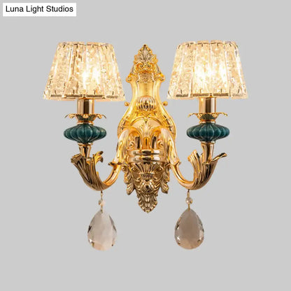 Gold-toned traditional seedy crystal drum wall mount sconce with two crystal lampshades and teardrop crystals