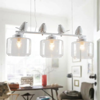 White ceramic bird pendant light with clear glass shades and metallic accents ideal for dining room décor