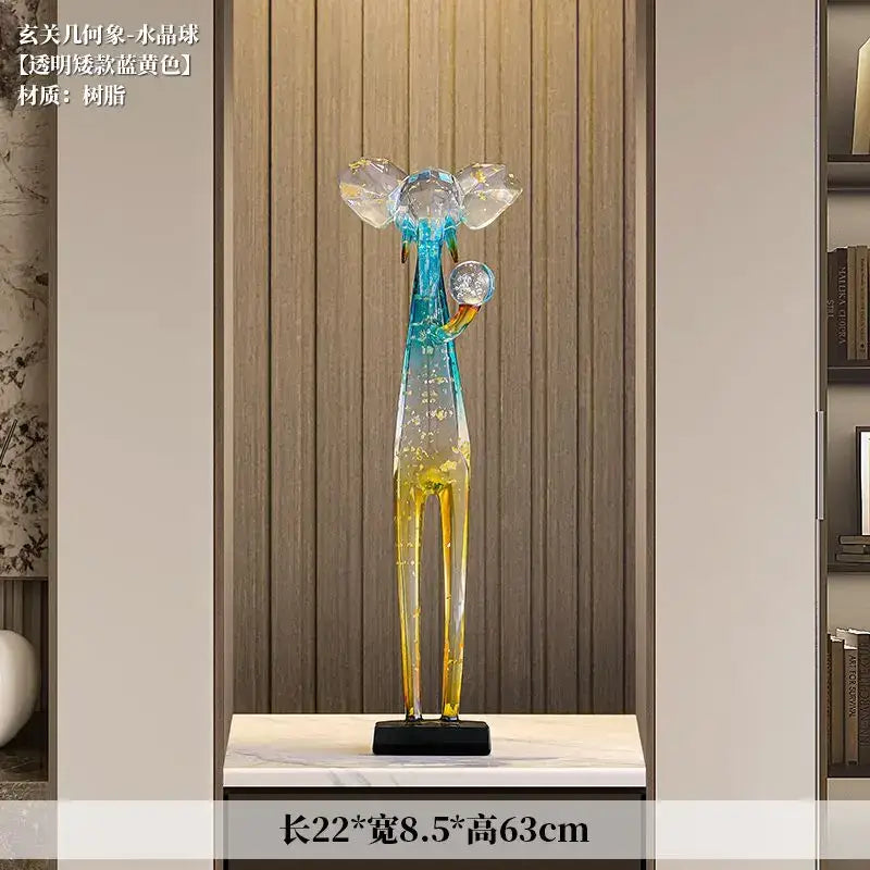 Translucent blue and yellow resin elephant floor decoration sculpture with crystal-like headpieces holding spheres