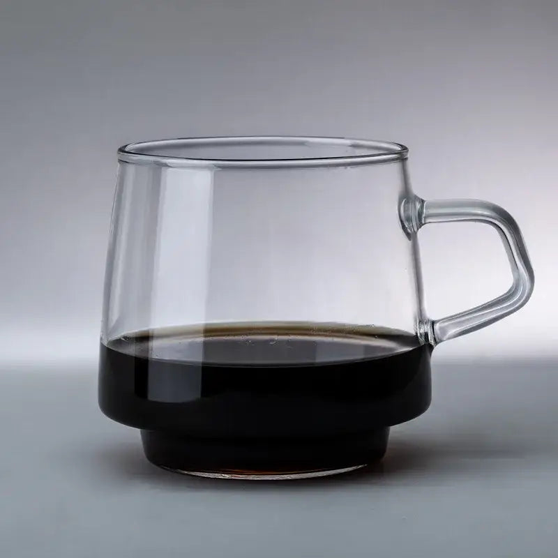 Clear glass coffee mug with sleek modern design and sturdy handle for heat resistant kitchen use