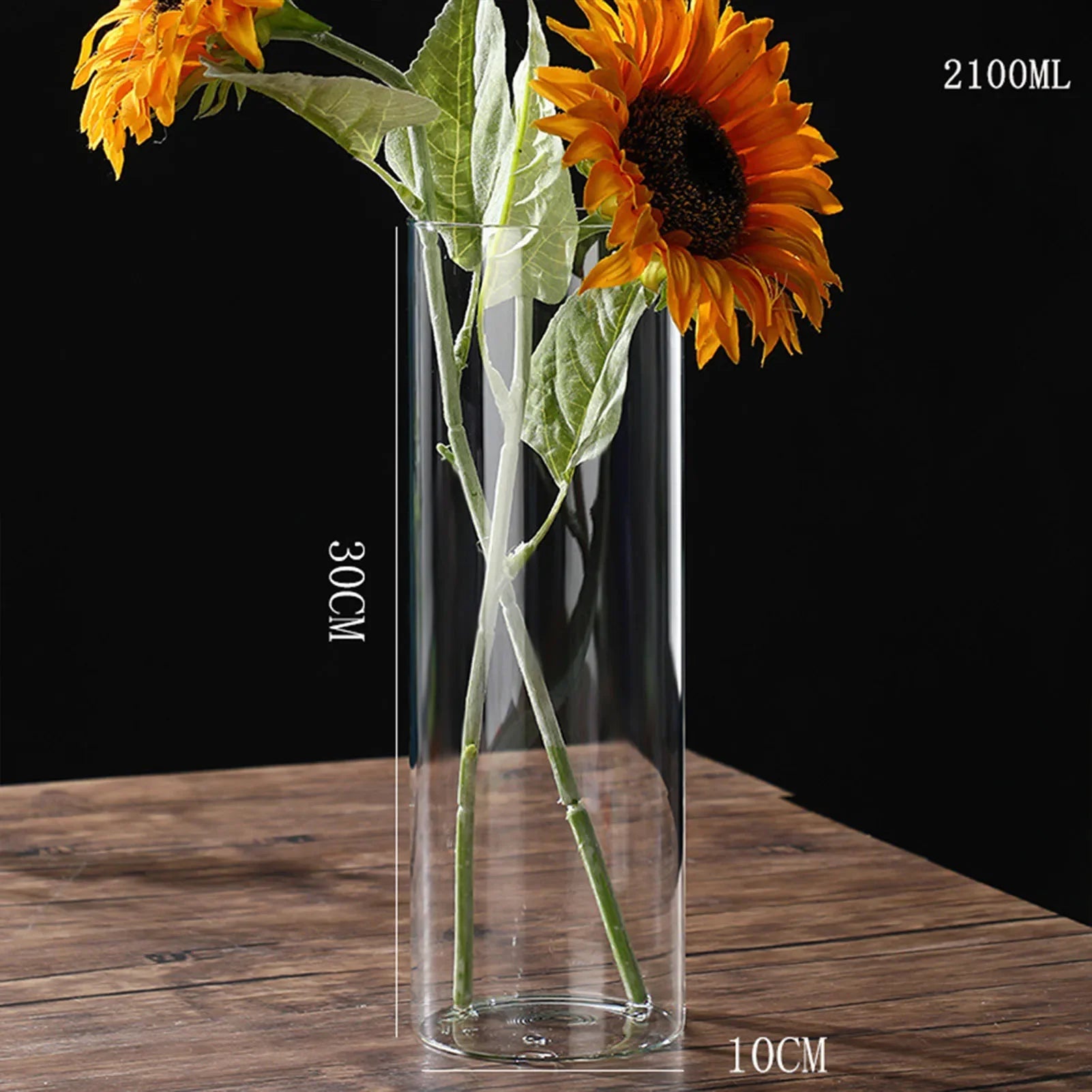 Transparent glass hydroponic vase 30cm tall 10cm wide holding vibrant orange sunflowers for home office wedding table