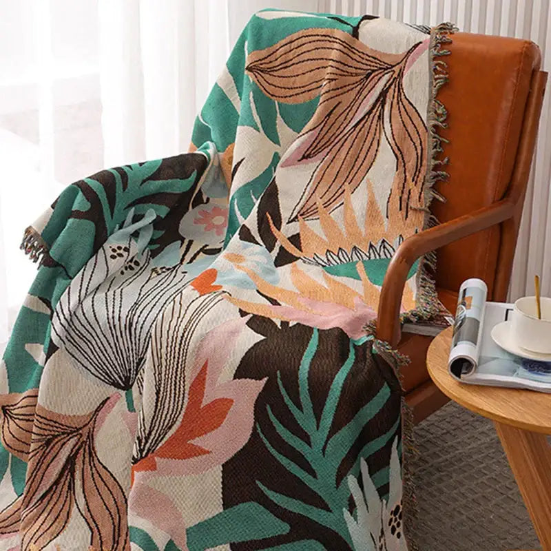 A cozy knit throw blanket with vibrant tropical leaf floral pattern in teal pink brown and cream for bedroom decorbites cozy knit