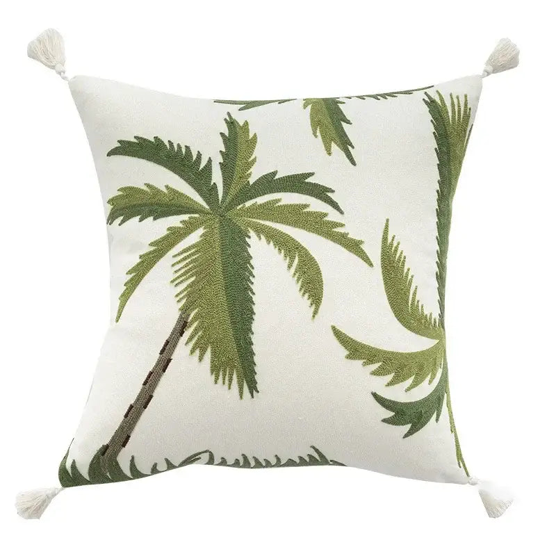 White cushion cover with embroidered patchwork green palm trees and cream tassels for tropical living room decor