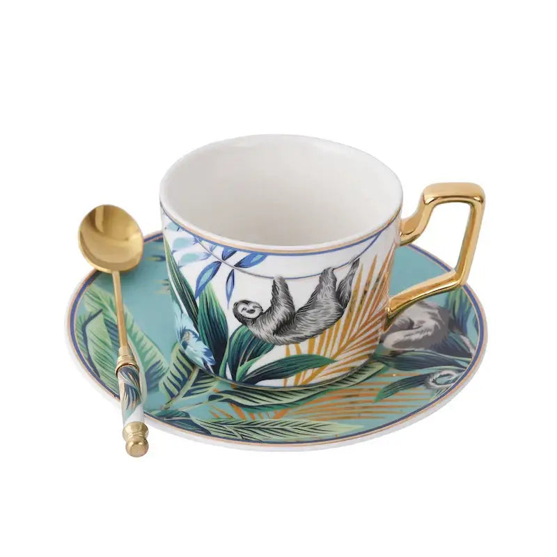 White ceramic tea cup with gold trim and sloth illustration from tropical pink and black toucan cup set