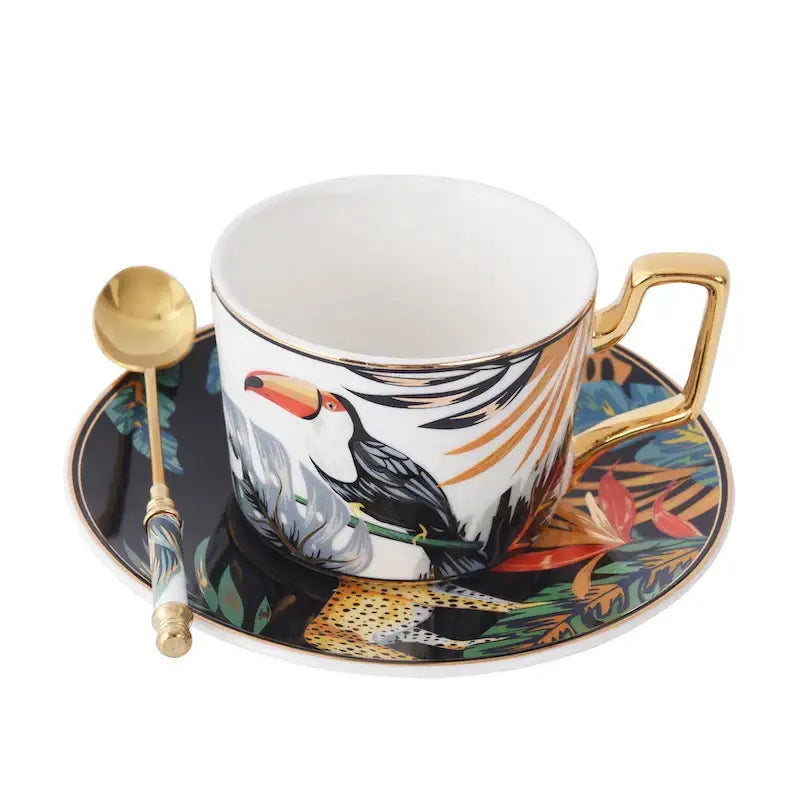 White ceramic tea cup with gold rim and tropical pink and black toucan design from porcelain cup set dining room collection
