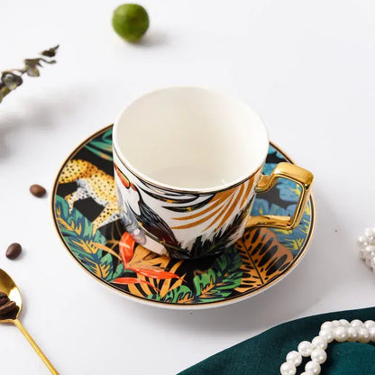 A vibrant jungle-themed tropical pink and black toucan porcelain tea cup set with gold handle and bold animal illustrations