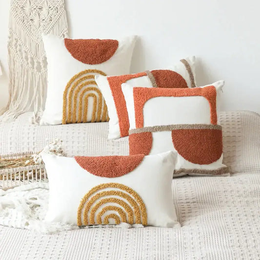 White cushion cover with textured earth-toned geometric tufted embroidery in burnt orange and mustard yellow decorbites design