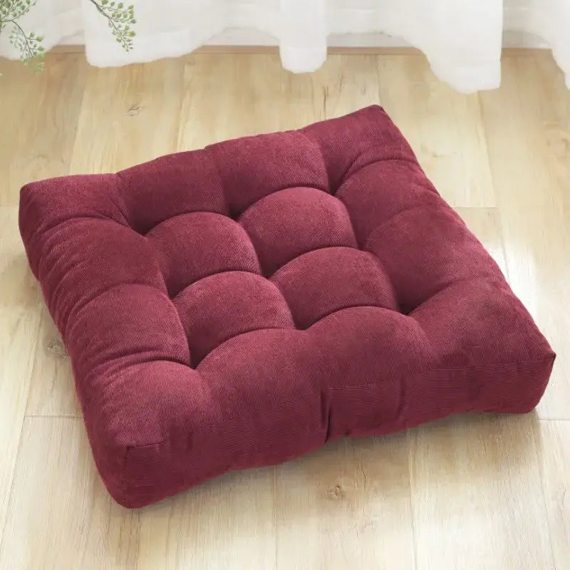 A plush deep red square tufted seat cushion made of corduroy fabric for decorbites corduroy floor seat use