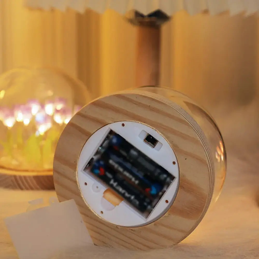 Wooden cylindrical decorbites tulip night light with natural grain finish and visible battery compartment with aa batteries