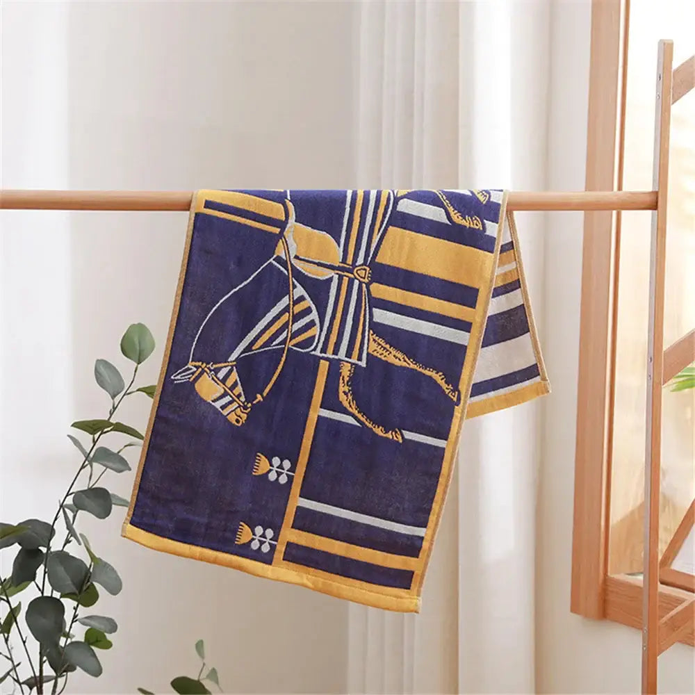 Navy blue and gold patterned cotton gauze hand towel with horse harness design hanging on wooden rack for face towel decorbites cotton gauze set