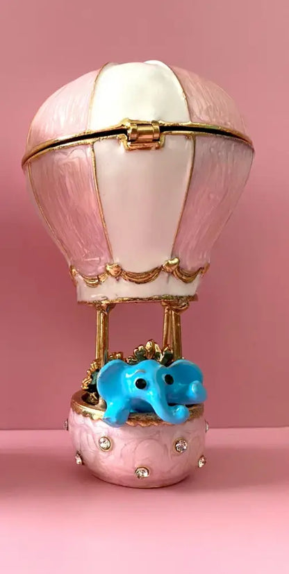 Delicate pink hot air balloon trinket box with gold accents and crystal animal figurines decorbites detail