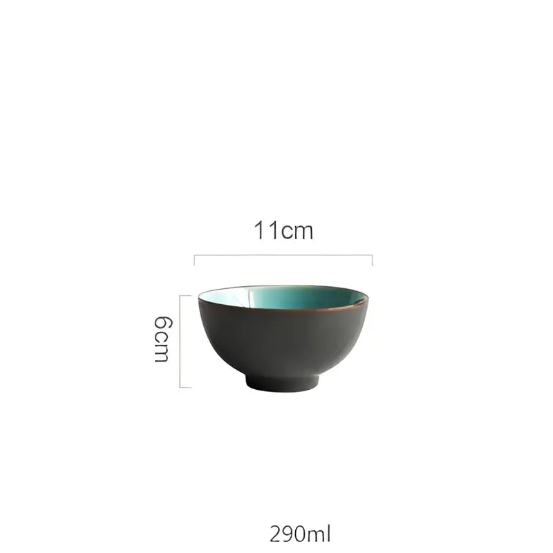 A sleek matte black ceramic bowl with vibrant teal interior and brown rim from turquoise ice cracking glaze tableware set