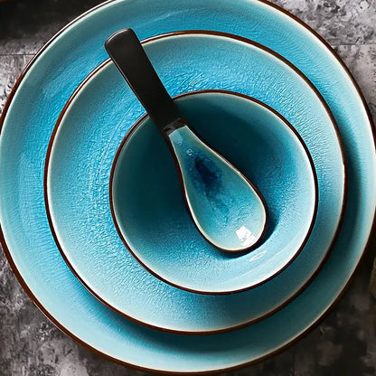 Set of three turquoise ceramic tableware pieces with ice cracking glaze and dark brown rims plus matching spoon