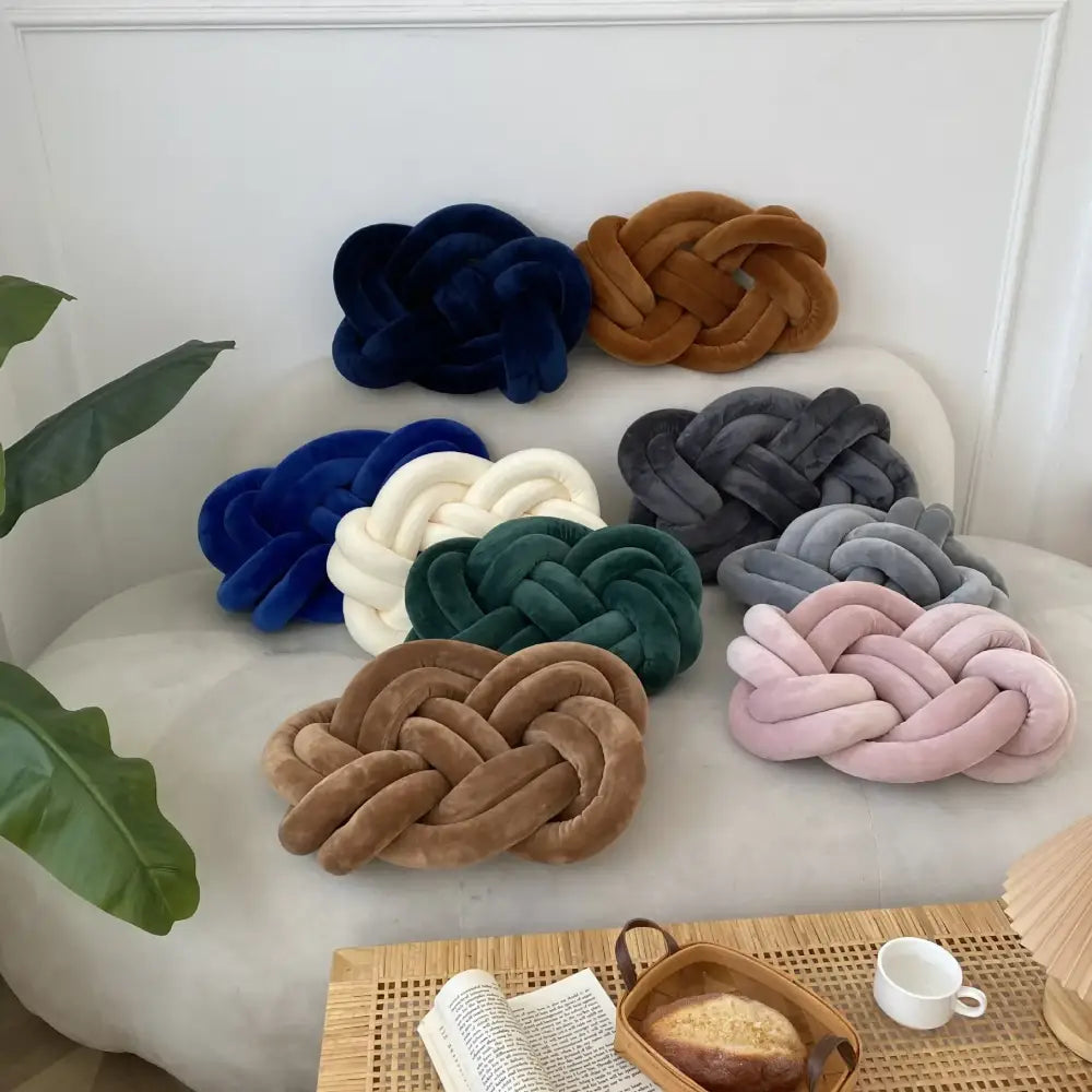A collection of velvet knot throw pillows in navy blue brown white green gray and pink for living room decor