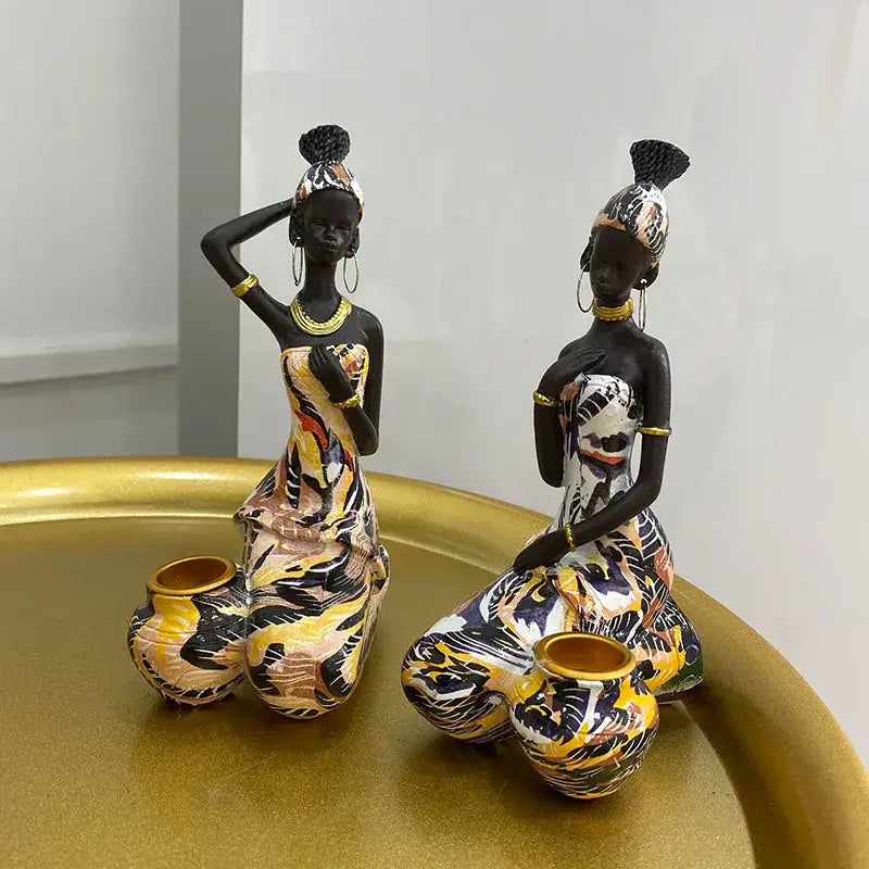 Two decorbites black woman candlestick figurines in vibrant yellow orange dresses with gold jewelry for living room decor