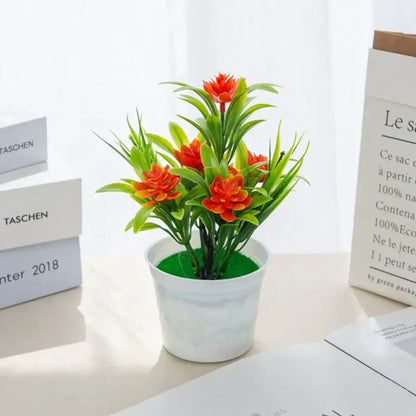 A vibrant orange artificial flowers bonsai arrangement with green leaves in a white ceramic flowers bonsai vase for decorbites artificial flowers decor