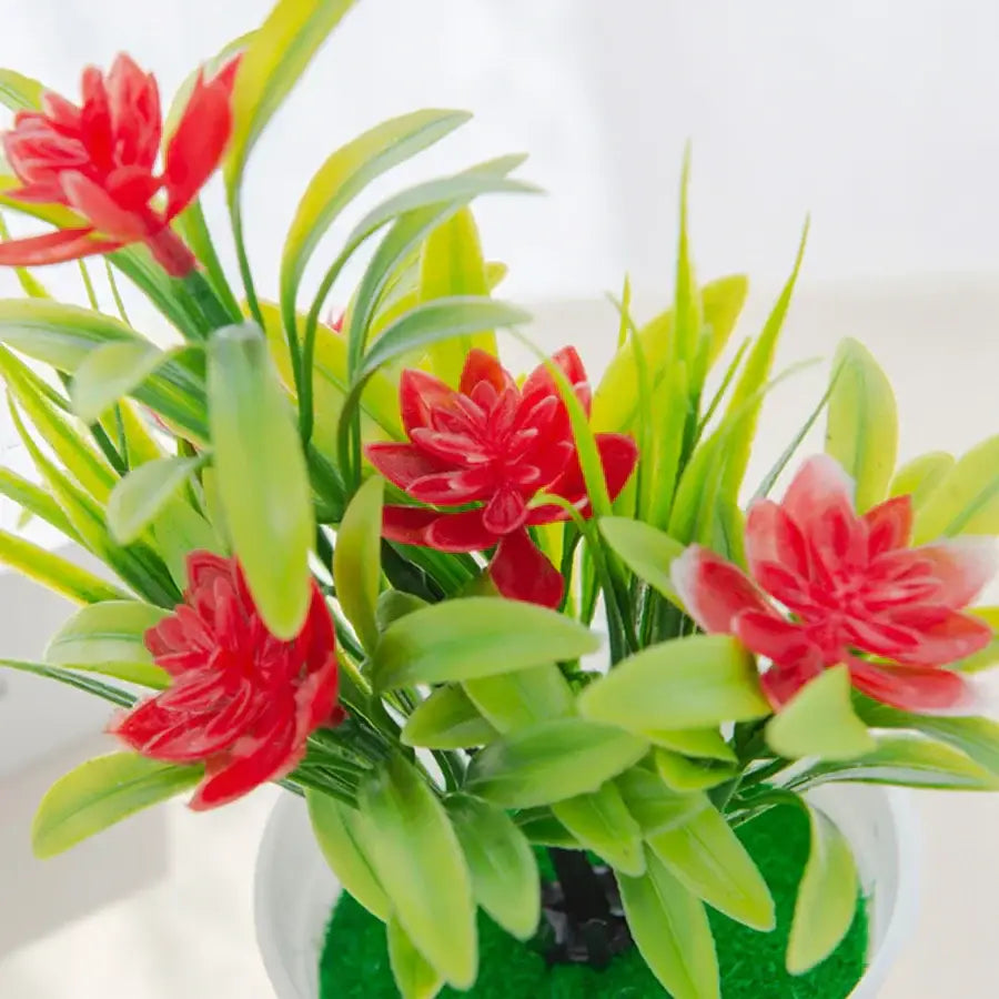 A vibrant artificial flowers bonsai vase with bright red blossoms and lush green leaves in a white pot for decorbites decor