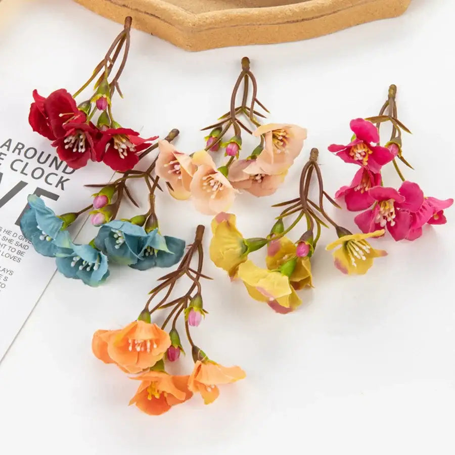 A collection of vibrant red pink peach blue yellow and orange decorbites artificial flowers with brown stems for living room decor