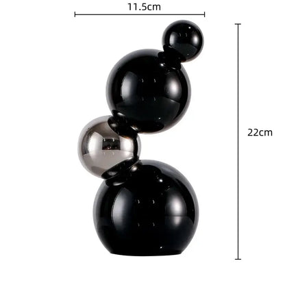 A sleek modern abstract sculpture of five glossy black and metallic silver decor spheres for home decor and crystal bubble decor
