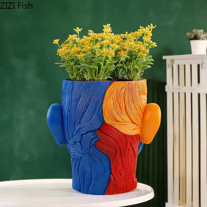 Vibrant human portrait resin vase with artificial flowers featuring bold blue orange and red abstract ceramic planter decorbites colorful human decor