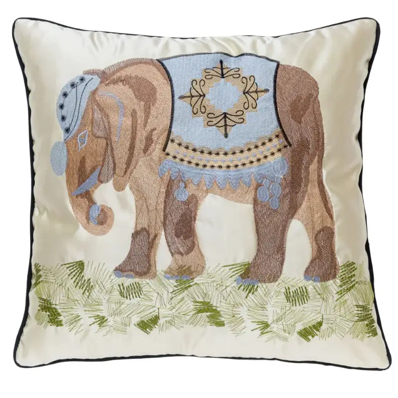 Cream-colored pillow cover with decorbites elephant embroidery in brown and light blue on grassy lime green decor