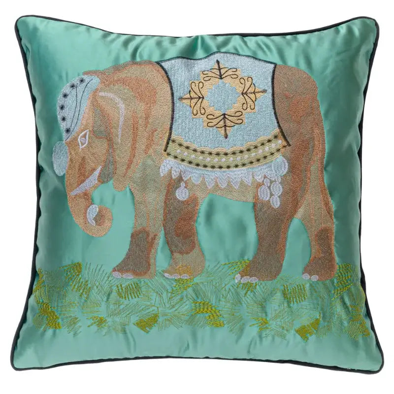 Teal satin pillow cover with vibrant lime green decorbites elephant embroidery standing on green grass decor