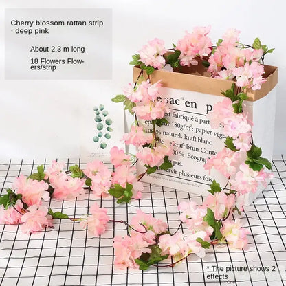 Pink cherry blossom floral garland made of rattan with green leaves in vibrant rose flowers vine garland decor