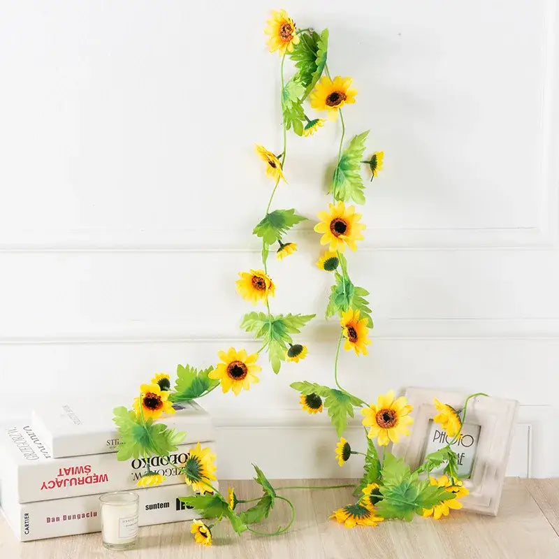 A vibrant yellow artificial sunflower vine with green leaves as part of a rose flowers vine garland decor