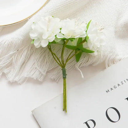 A delicate white artificial flower stamen bouquet with green stems and leaves for living room decor