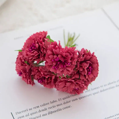 A cluster of deep red decorbites carnation stamen silk flowers with delicate layered petals and small purple centers for living room decor
