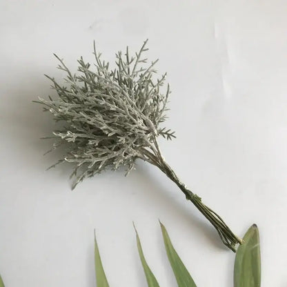 A delicate frosted silver artificial dried flower bouquet with fine twig-like branches in a white vase for living room