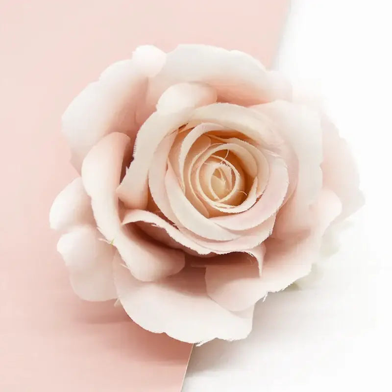 A delicate blush pink silk artificial rose with layered petals from decorbites artificial flowers for wedding decor