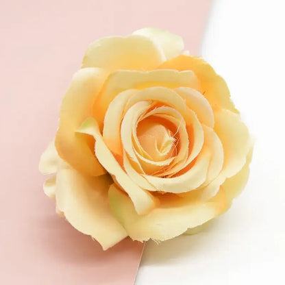 A delicate peach-colored decorbites artificial flower with layered petals for wedding and living room decor