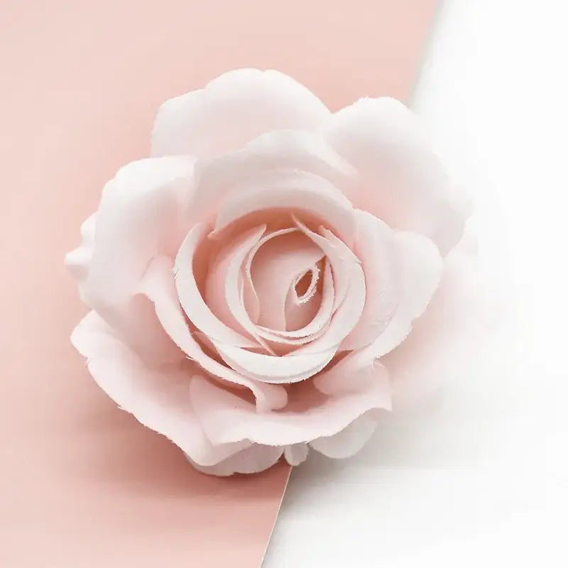 A delicate blush pink silk artificial rose with layered petals from decorbites artificial flowers for wedding decor