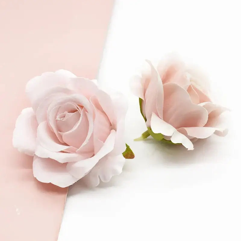 Two delicate pink silk artificial flowers with green stems on a pale pink and white background by decorbites artificial flowers