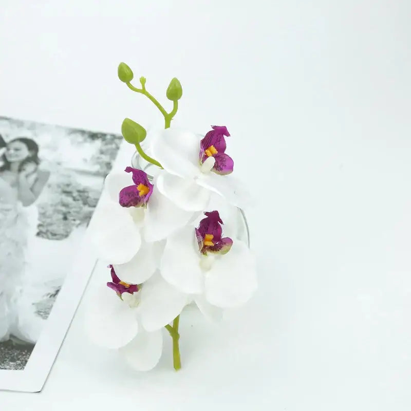 A delicate vibrant silk butterfly orchid bouquet with white petals and purple centers for wedding and home decor